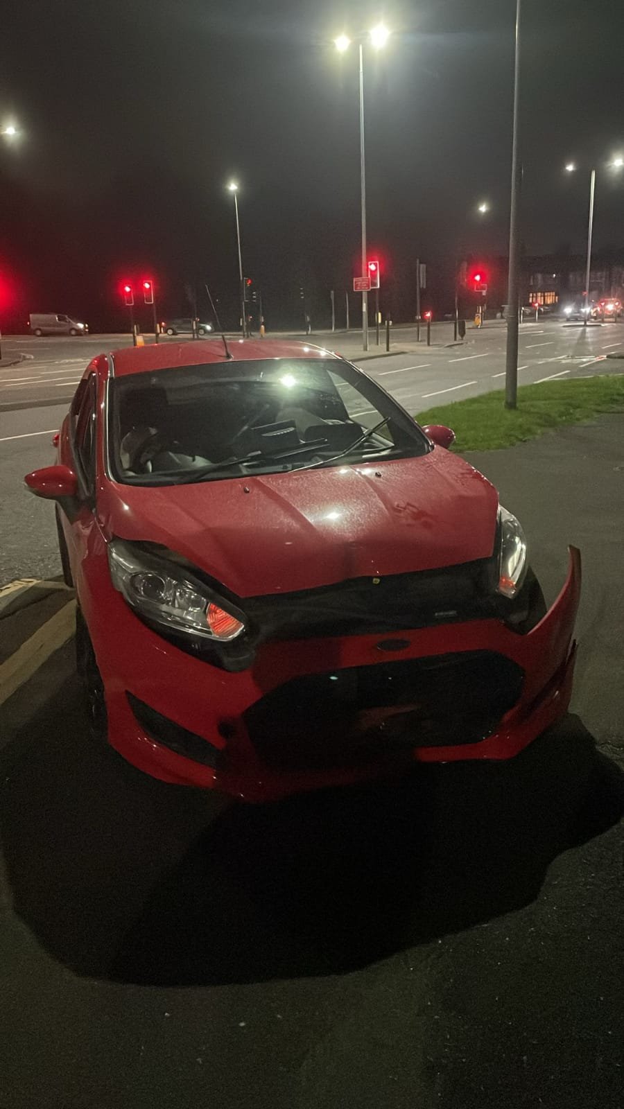 Car with front damage awaiting recovery.