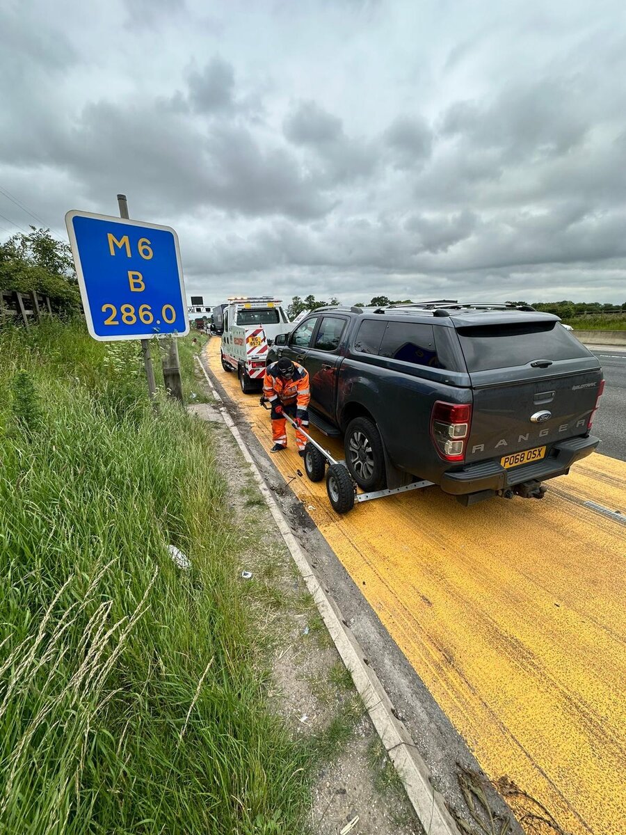 Breakdown Man loading a black Ford Ranger Wildtrak onto a recovery trailer beside the M6 marker post 286.0 near Atherton.