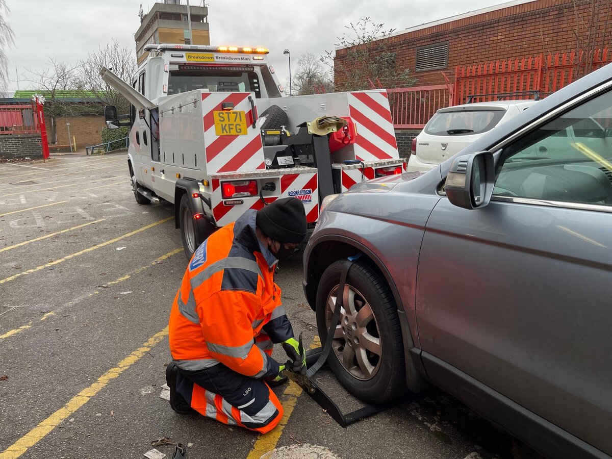Simon strapping a Honda CR-V to the flatbed for a roadside recovery.