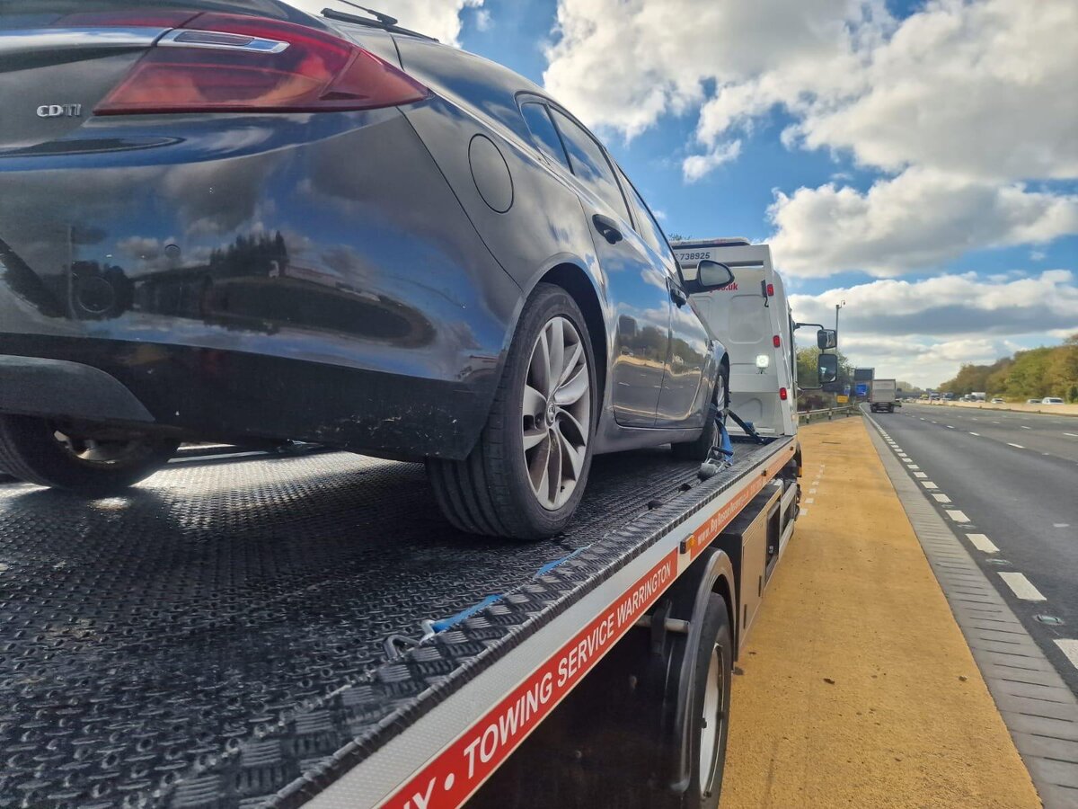Black Vauxhall Insignia loaded on Breakdown Man's recovery truck on the motorway — towing service from Warrington across the North West.